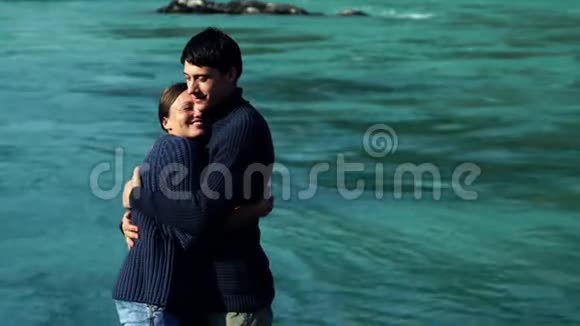 女孩和男孩在蓝水的背景上拥抱然后互相看着亲吻视频的预览图