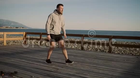 男运动员正在海边的木平台上做视频的预览图