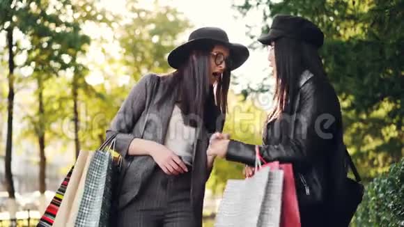 兴奋的女孩看着她的朋友在袋子里买东西问价格和收藏品的问题并表达视频的预览图