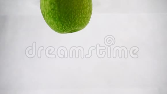 一个绿色多汁的苹果被扔进水里里面有泡泡慢动作录像视频的预览图