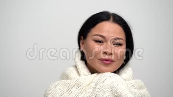 可爱的亚洲女人在白色背景下轻轻地带着白色围巾避难视频的预览图
