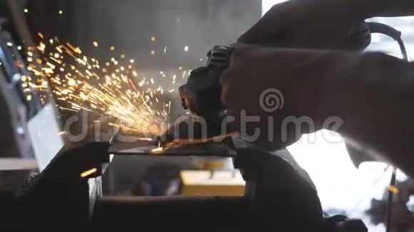 在车库用圆锯把男焊工锯金属的手臂合上专业修理工或视频的预览图