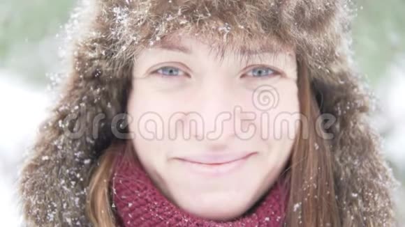 一个戴着温暖冬帽的年轻女子正在享受降雪视频的预览图