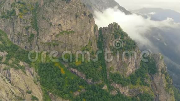 4k高空接近高岩山脉笼罩在高加索的云层中视频的预览图