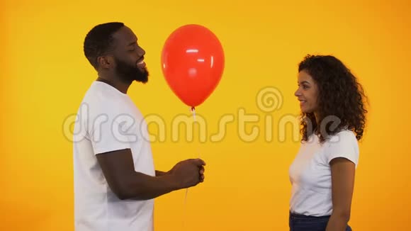 微笑着向可爱的女人赠送气球生日礼物约会视频的预览图