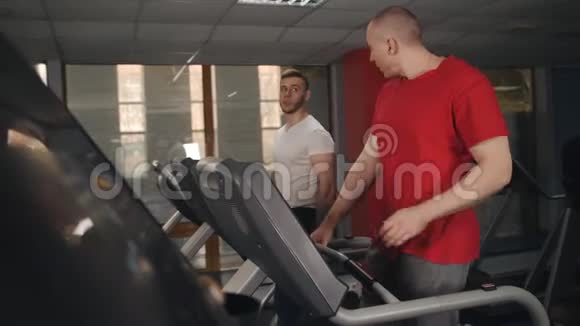 两个人在健身房进行跑步机训练视频的预览图
