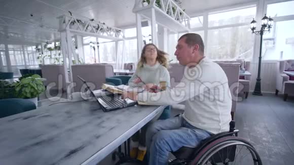 自由职业商人在轮椅上残疾妇女使用智能计算机技术开发和规划视频的预览图