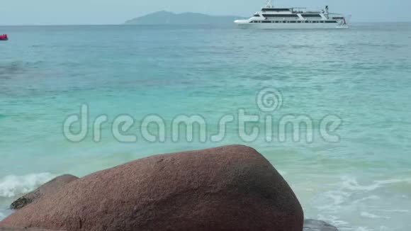 塞舌尔普拉斯林岛背景上有人在蓝色海水中移动的机动船旅游放松视频的预览图