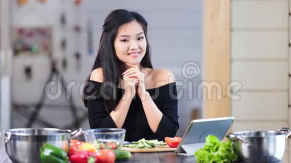 可爱的亚洲少女微笑着摆姿势在厨房里看镜头的肖像视频的预览图