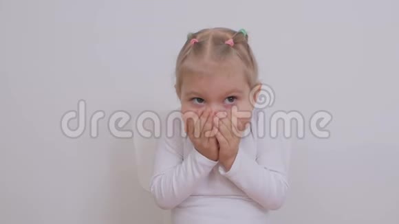 两岁的可爱女孩用手掌遮住她的脸视频的预览图