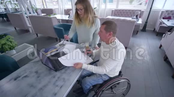 残疾成年男性轮椅残疾人士的专业教育以及使用智能电脑技术的女性教师视频的预览图