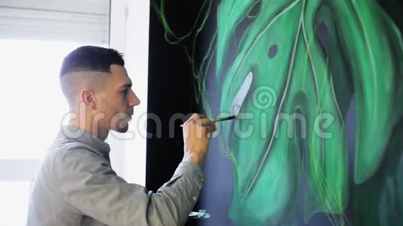 涂鸦艺术家在萨隆用油漆在墙上画树枝视频的预览图