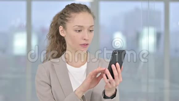年轻女商人对智能手机损失的回应视频的预览图