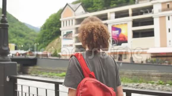 旅行者带着红色背包在山上行走旅行生活冒险假期自由概念视频的预览图