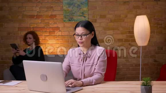 成人亚洲女商人在办公室室内的笔记本电脑上打视频电话的特写镜头女性雇员视频的预览图