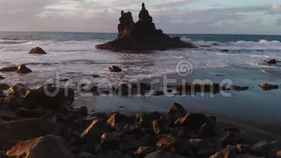 海洋中一块孤立岩石的鸟瞰图黑火山沙滩大西洋加那利特内里费贝尼霍海滩视频的预览图