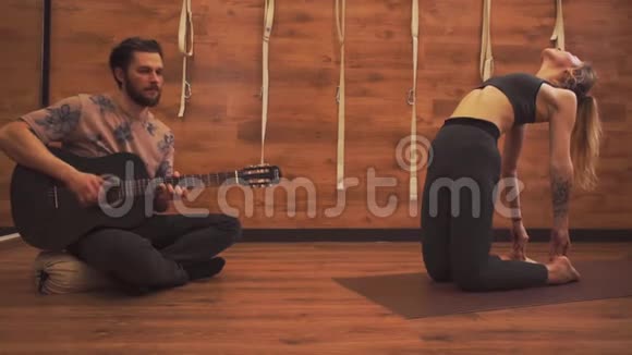 男人弹吉他女人练习瑜伽视频的预览图
