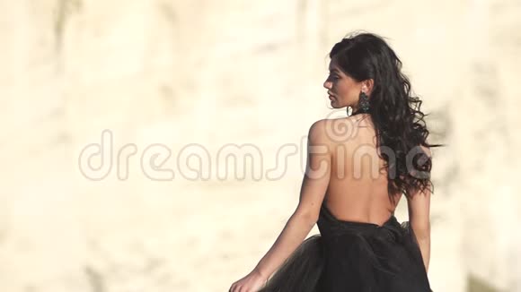 穿着黑色裙子的年轻女子在风中翩翩起舞视频的预览图