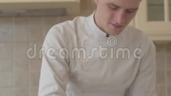 现代厨房里年轻的集中披萨店老板穿着厨师制服在家里准备披萨面团视频的预览图