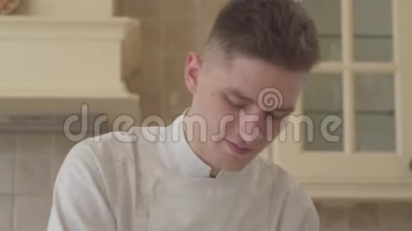 特写年轻集中厨师身着厨师制服在家厨房准备食物的肖像食物概念视频的预览图