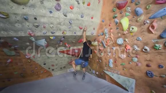 成年攀岩者正在攀岩健身房里攀岩男子在室内攀岩运动墙上锻炼视频的预览图
