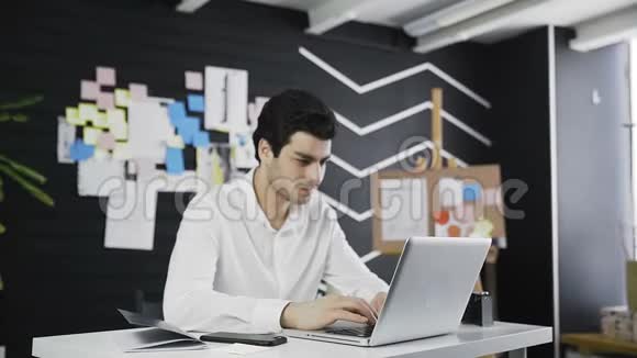 快乐男办公室经理看着坐在他工作场所的相机视频的预览图