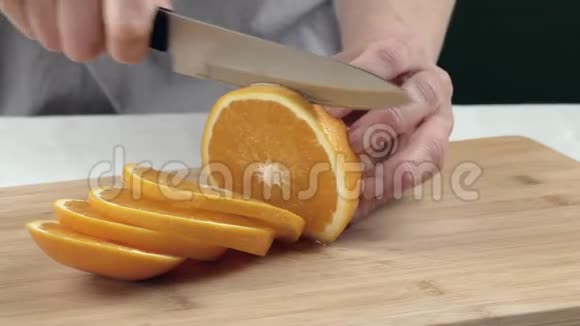 女性的手在切割板上切割一个橙色关门视频的预览图