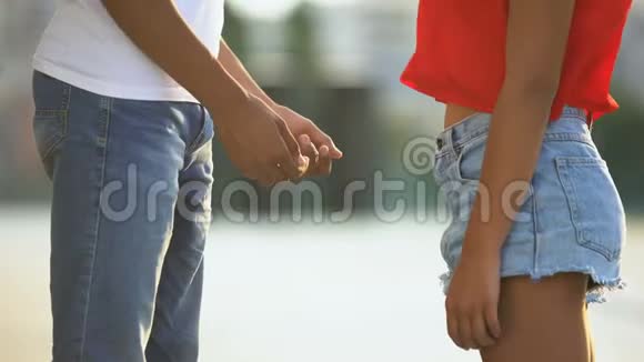 年轻的美国黑人夫妇牵着手在青春期害羞的感情同情视频的预览图