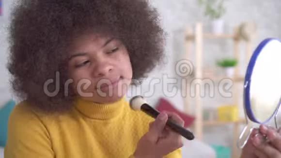 描绘非洲裔美国妇女积极化妆照镜子在现代公寓视频的预览图