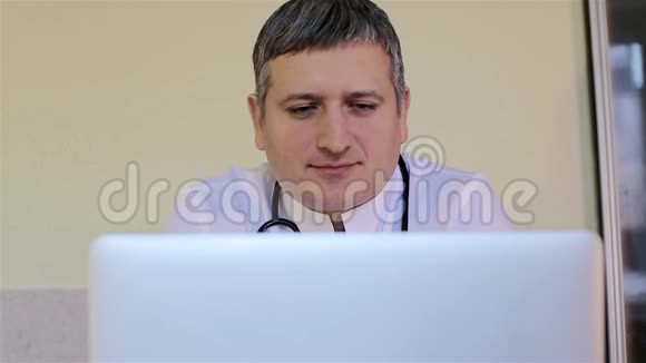 医生看着笔记本电脑微笑着视频的预览图