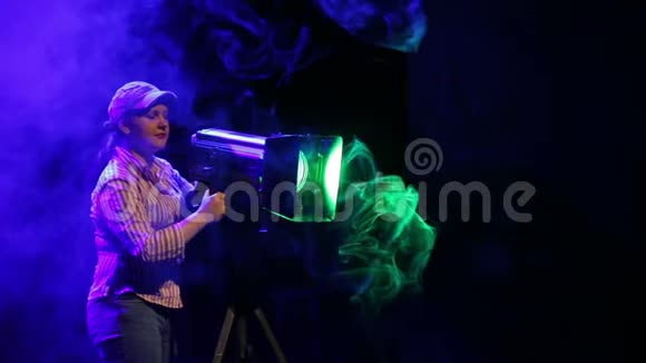 舞台上的一位年轻女子用一台用一台戏剧轮廓投影仪感应烟雾中的光线视频的预览图