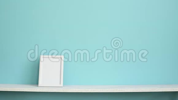 现代客房装饰与相框模型白色架子靠在青绿色的墙壁上用手放下盆栽的施法勒视频的预览图