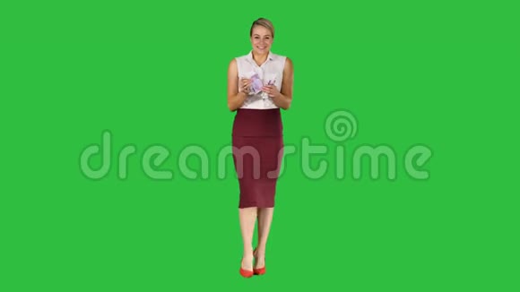 美丽的年轻商务女性显示钱在凸轮上的绿色屏幕铬键视频的预览图
