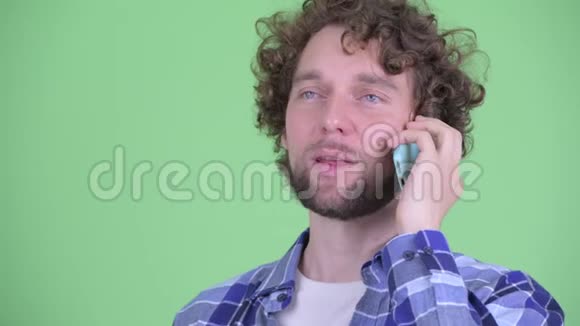 一张快乐的年轻留胡子的时髦男人的脸在电话里说话视频的预览图