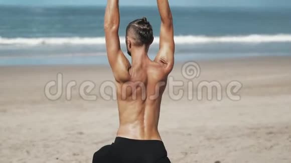 背面风景运动男子在沙滩上做瑜伽运动有海洋背景视频的预览图