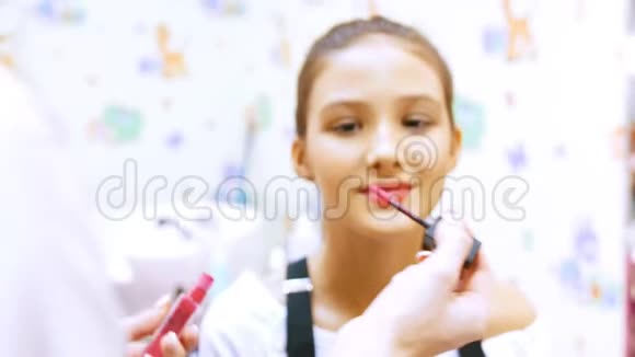 化妆师用奶油口红年轻女孩视频的预览图