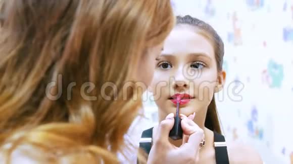 化妆师用奶油唇膏漂亮的年轻女孩视频的预览图