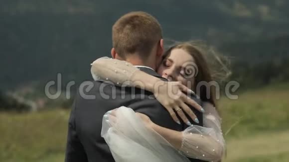 新郎新娘在山上玩得开心新婚夫妇拥抱视频的预览图