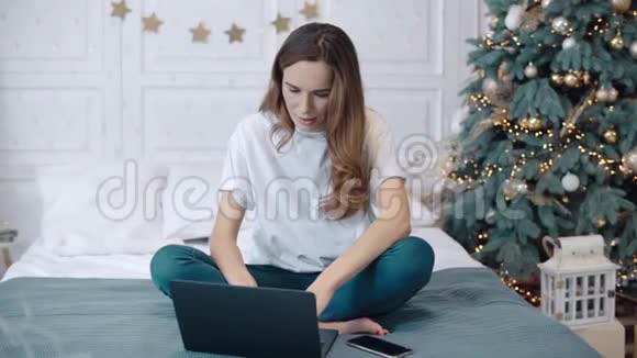 微笑的女人在豪华住宅的电脑上读积极的新闻视频的预览图