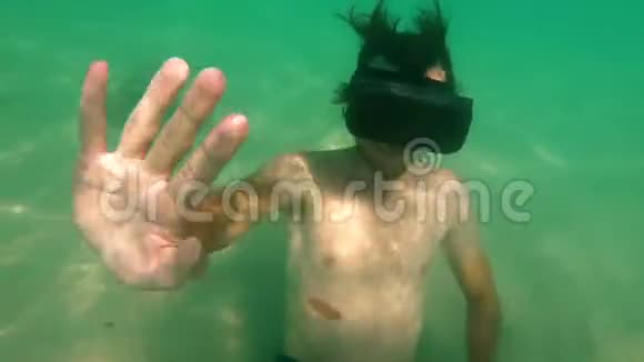 水下拍摄的一个年轻人使用VR耳机躺在海底一个戴着虚拟现实眼镜的人感觉就像视频的预览图