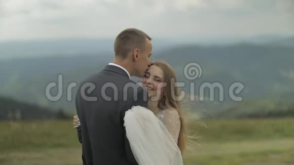 新郎新娘在山上玩得开心新婚夫妇拥抱视频的预览图