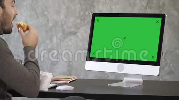 商人一边吃东西一边打网络电话绿色屏幕模拟显示视频的预览图
