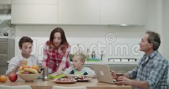 健康的午餐盒妈妈为她的两个儿子做准备并在早上的餐桌上把他们带到餐桌上视频的预览图