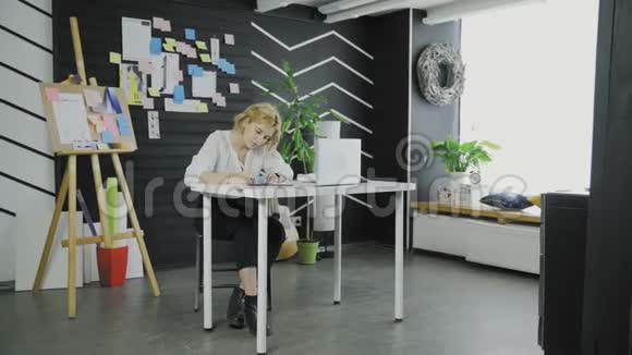 商务女性坐在桌旁时在贴纸上写下一些东西视频的预览图