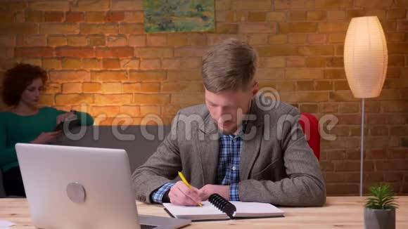 成年商人使用笔记本电脑在办公室室内做笔记的特写镜头使用平板电脑的女雇员视频的预览图