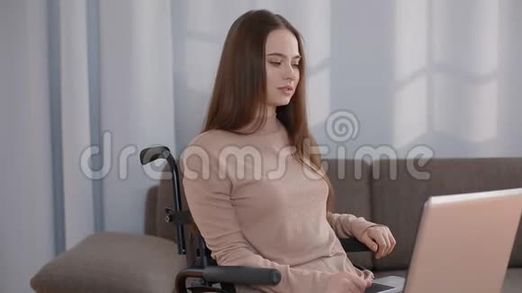 带手提电脑在家工作的残疾青年妇女视频的预览图