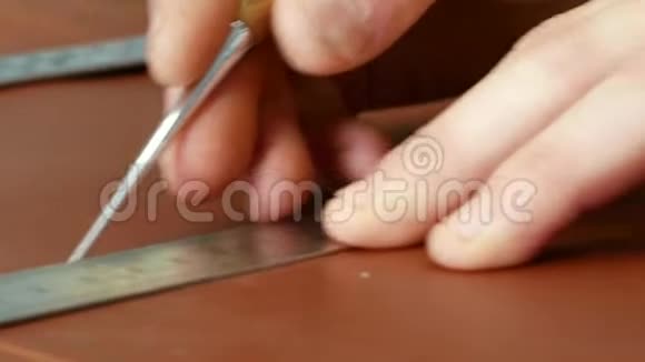 工匠用尺子在皮布上做一行标记特写视频的预览图