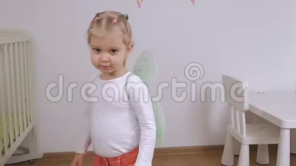 一个带着玩具蝴蝶翅膀的小女孩在后面跳着舞视频的预览图