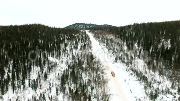 一辆装载木材的卡车沿着一条雪道行驶载着原木视频的预览图