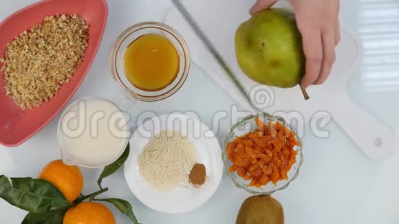 厨房里的砧板上女人的手切梨花烹饪健康的食物4K视频的预览图
